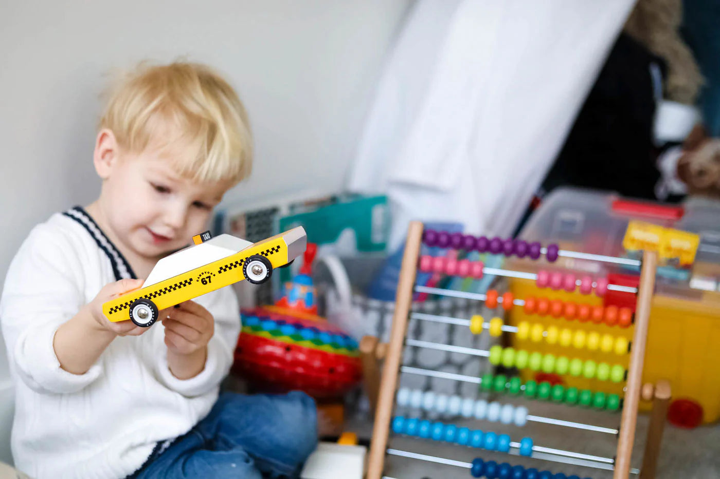 Child holding a Candylab yellow taxi toy