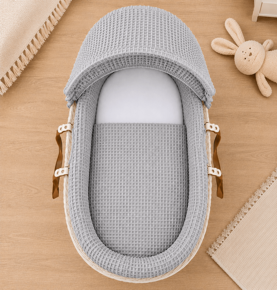 Moses basket with grey waffle bedding and hood