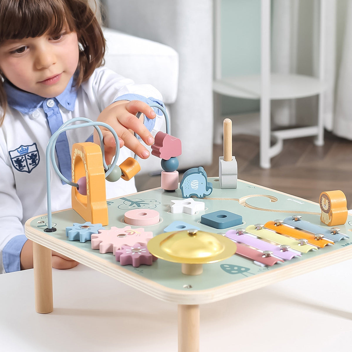 Birds-eye top view showing the interactive puzzles, animal shapes, and bead tracks on a Montessori wooden toy.