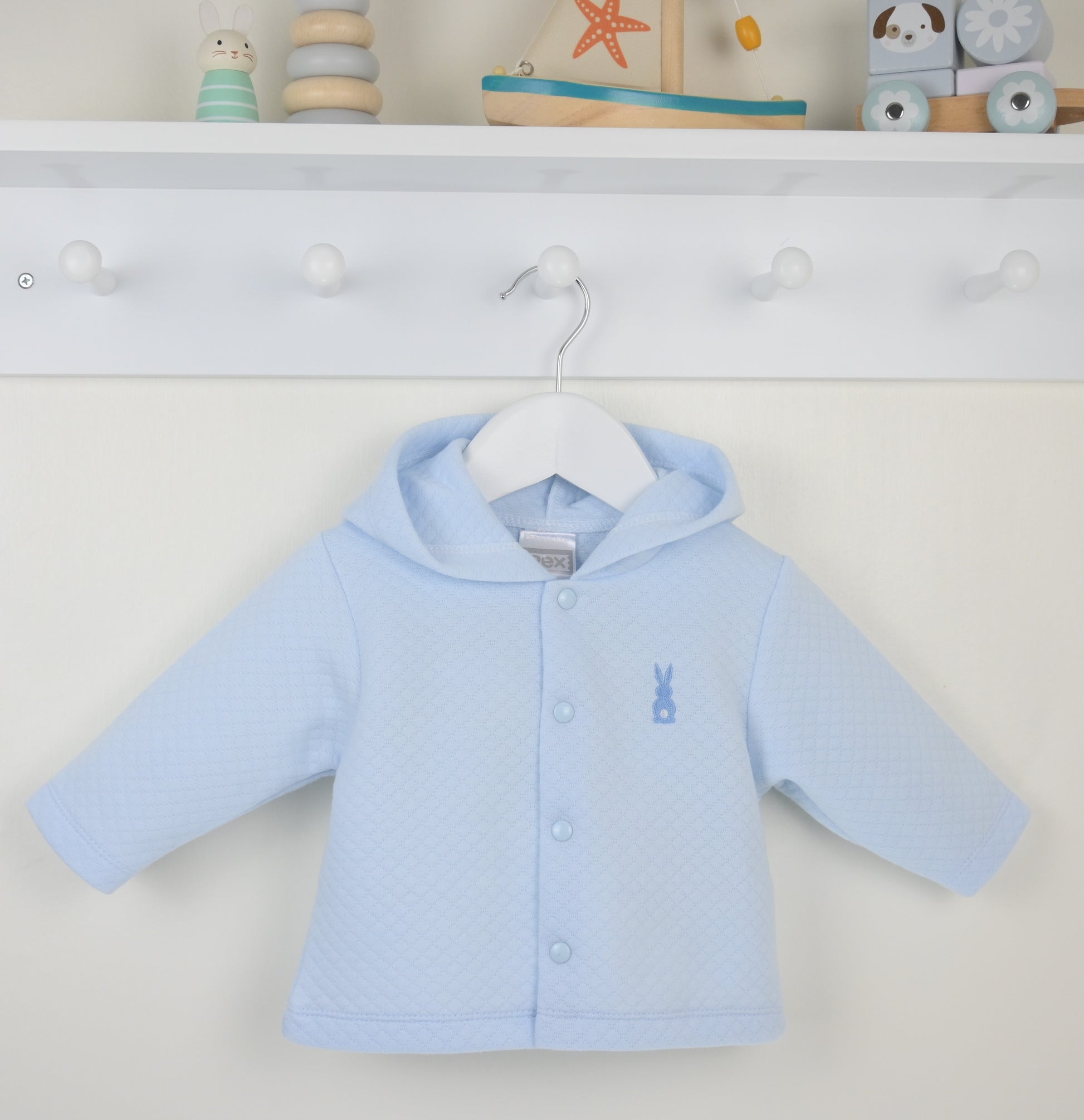Light blue baby jacket on a hanger against a white background with toys in the background.